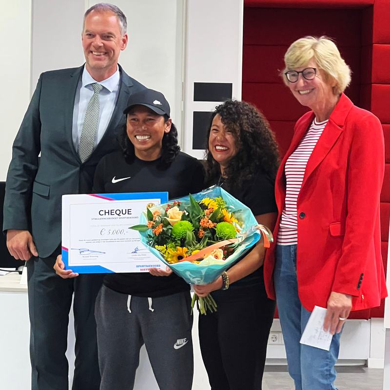 Wethouder Sport Ronald Weerwag, Cheryl Sinto, Gaby van Berg en Dini Bouwmeester met de cheque en bloemen van het Sportakkoord.