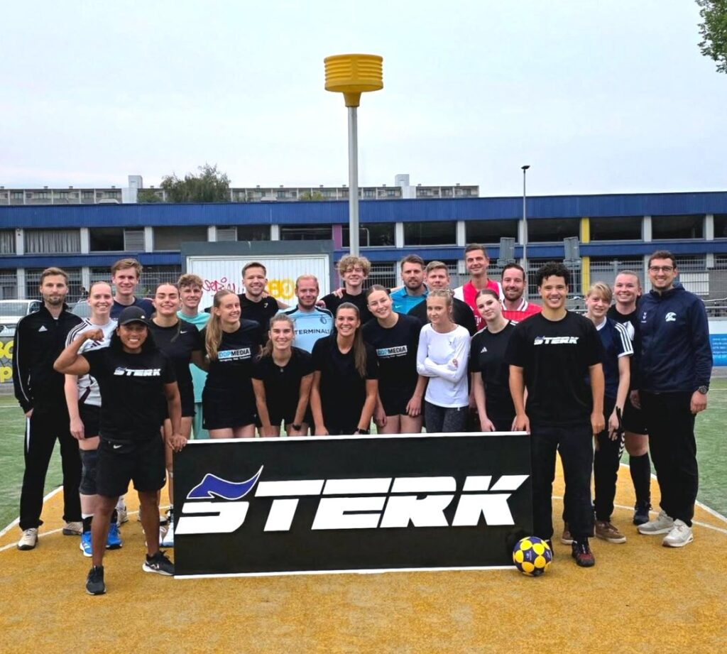 Het korfbalteam met het STERK-bord op het veld.